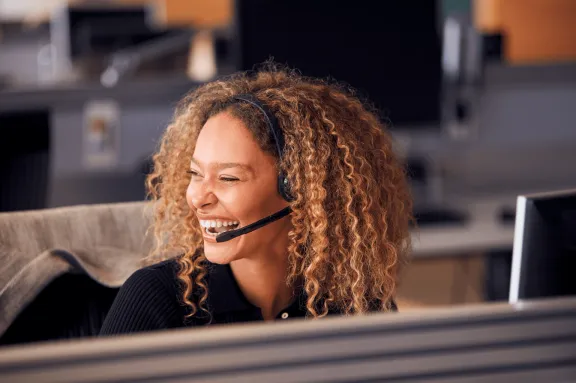 Lachende vrouw belt met headset