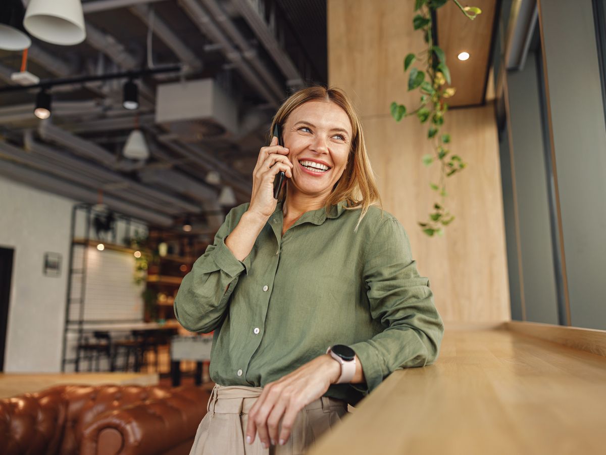 Vrouw belt lachend met haar mobiele telefoon