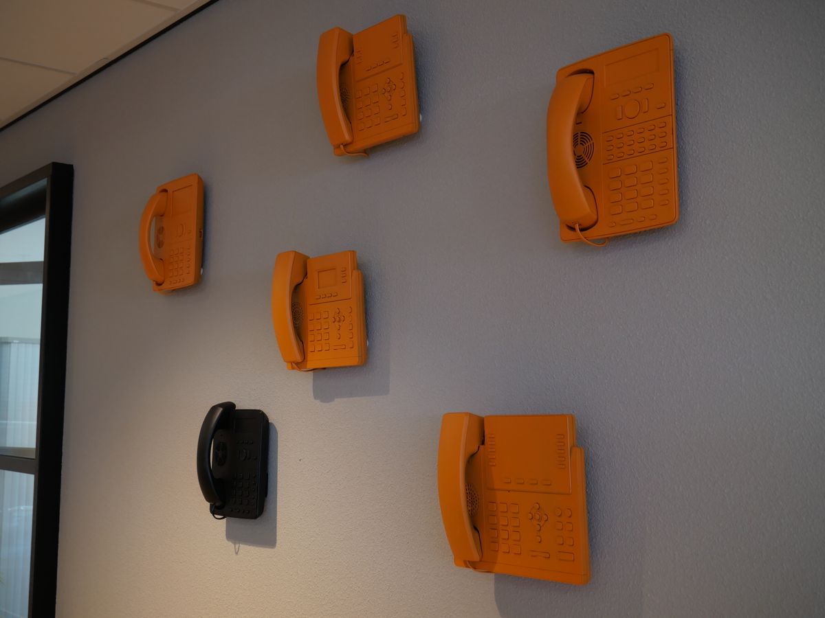 Oranje telefoons aan de wand bij speakup